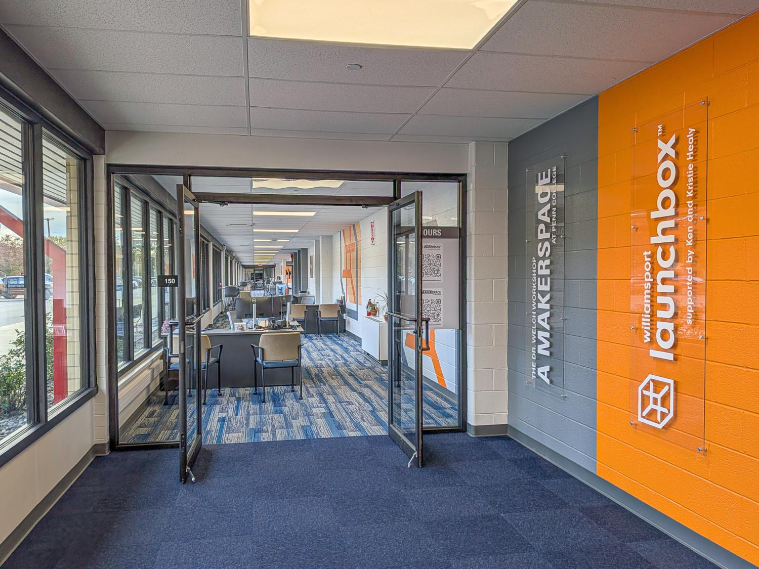 A glass office doorway with an orange entrance wall sign