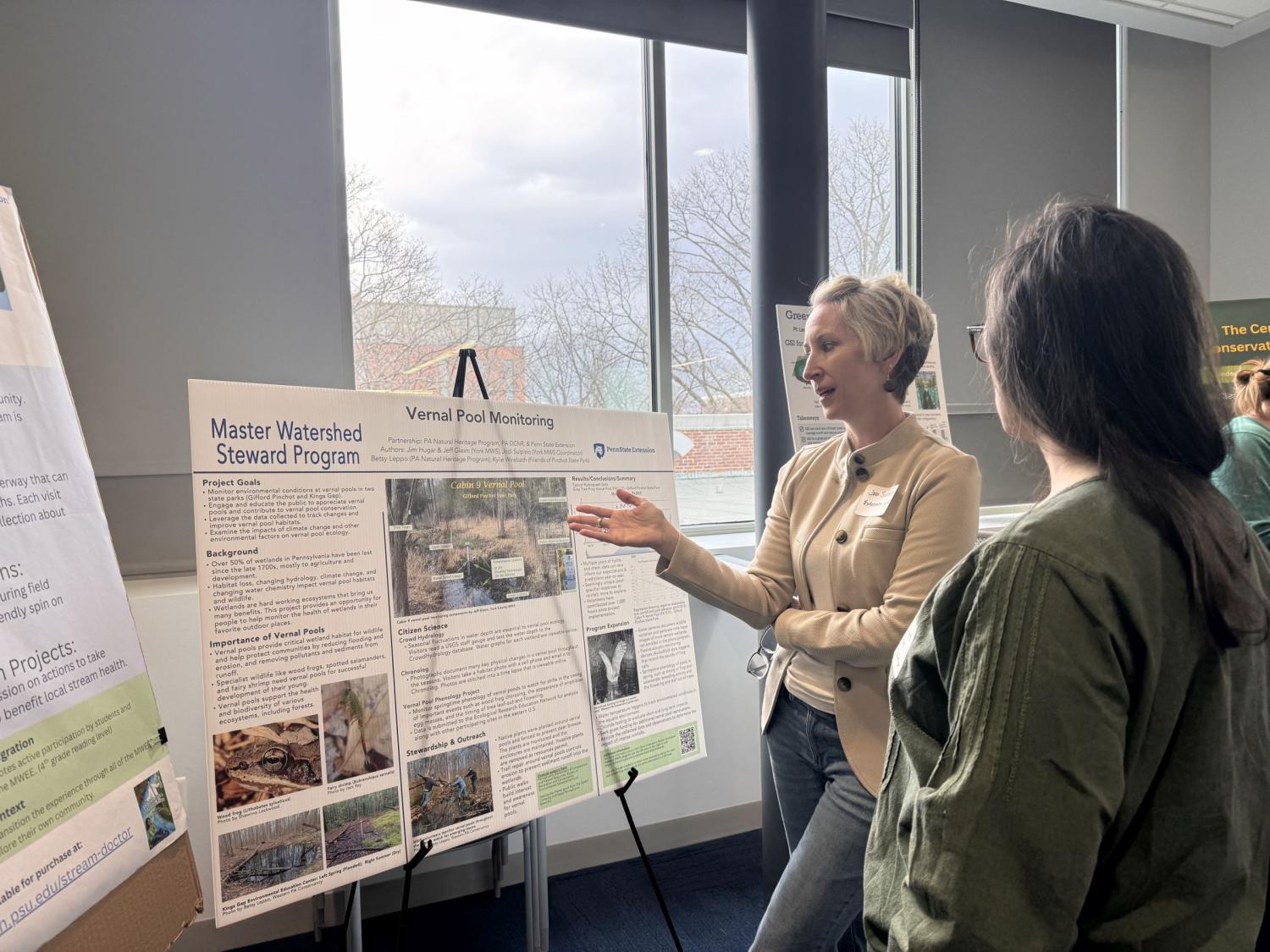 Two people looking at a poster