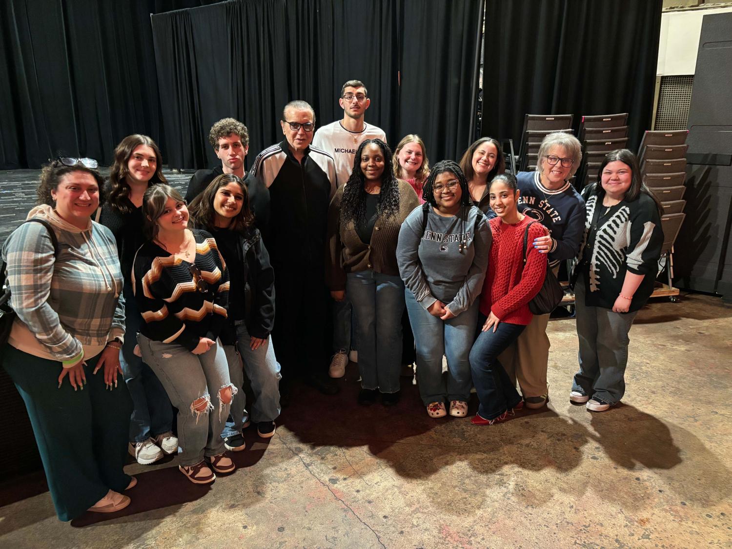 students posing for a photo in front of a stage