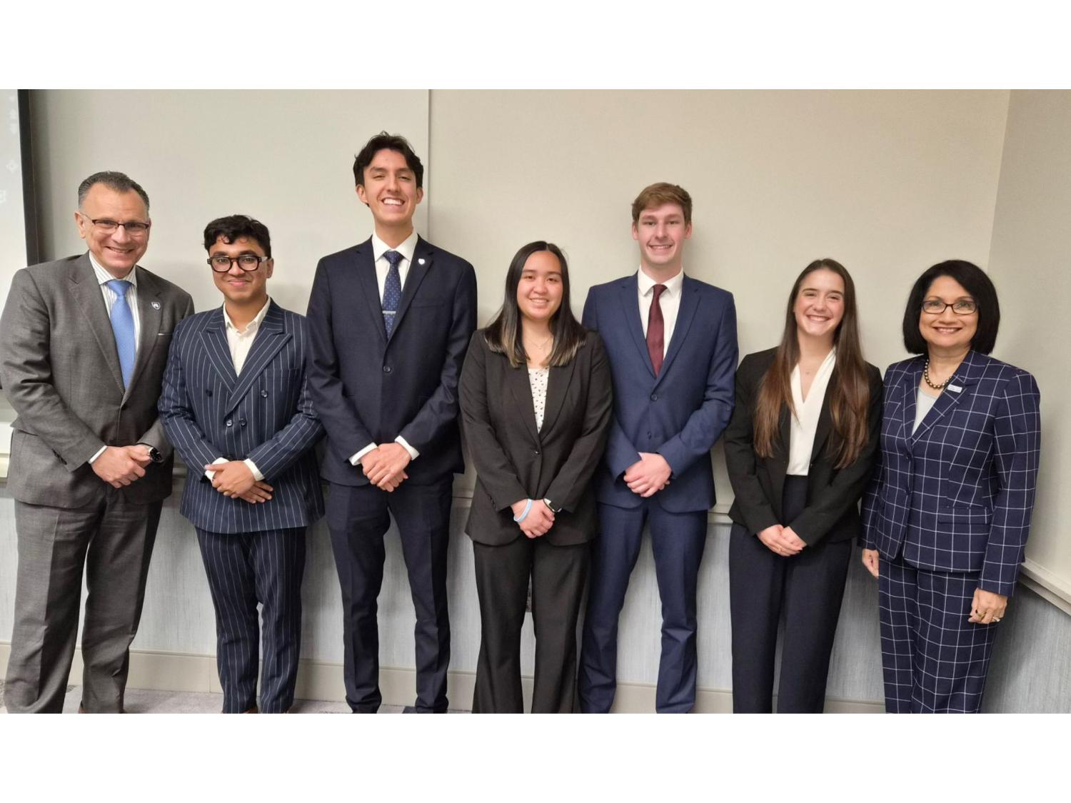 Seven individuals wearing suits pose for the camera