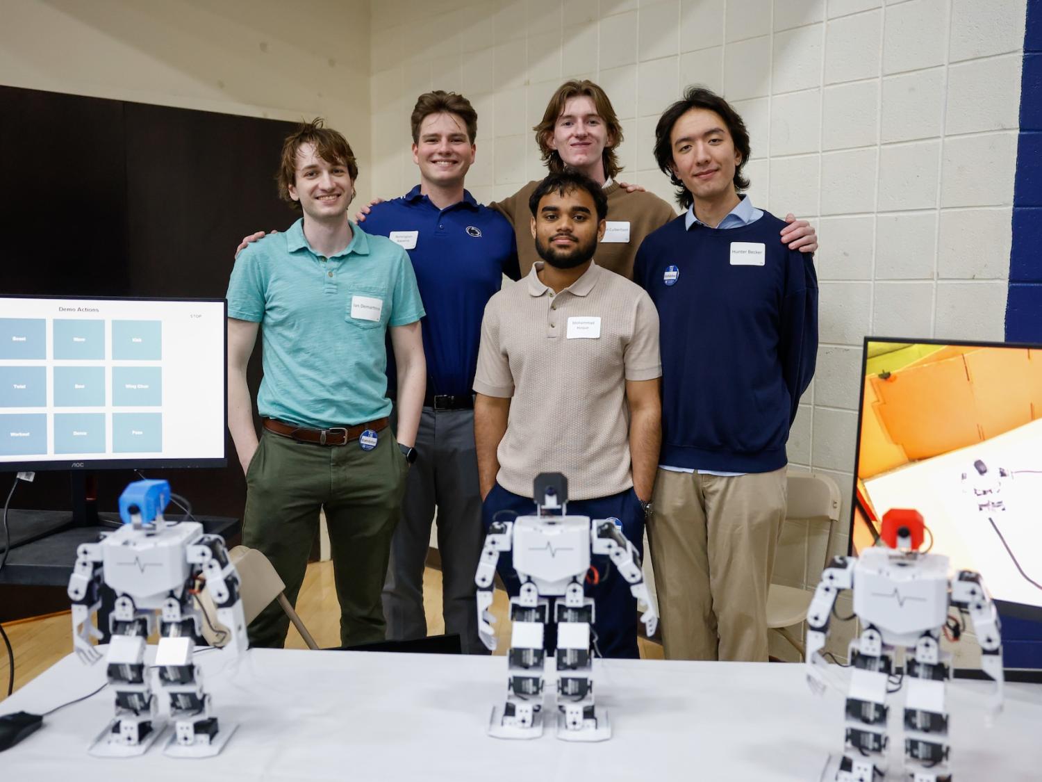 five brandywine students standing behind three robots