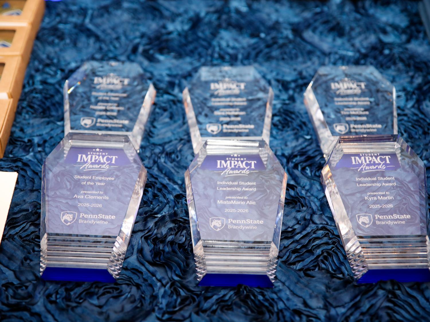 clear plaques for students on a blue tablecloth