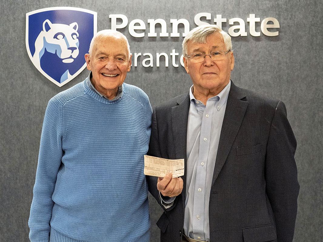 Mike Abdalla and Joe clifford pose for a photo, showing one of Clifford's old grade reports