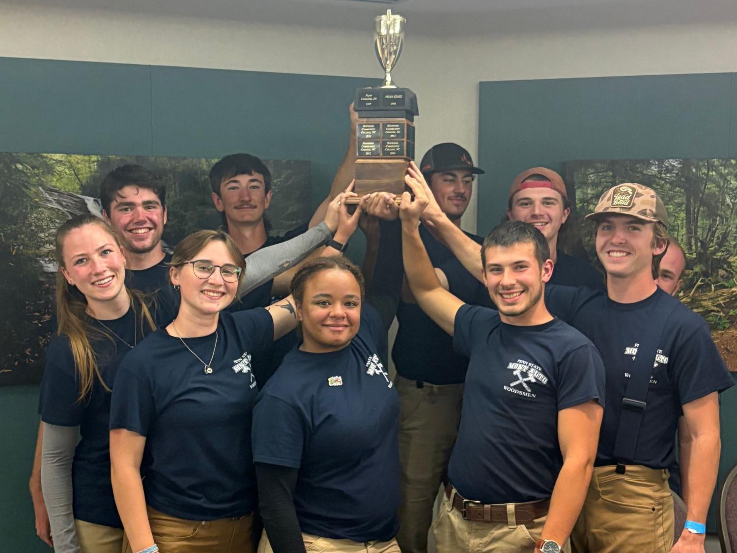 A group of Penn State students are holding a trophy.
