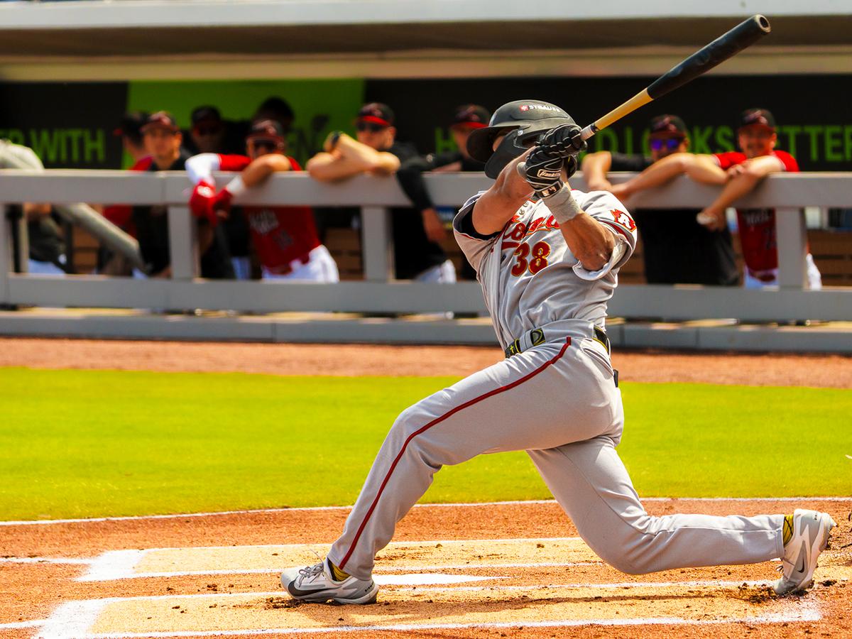Will Taylor of the Altoona Curve swings at a pitch in front of the dugout during a game.