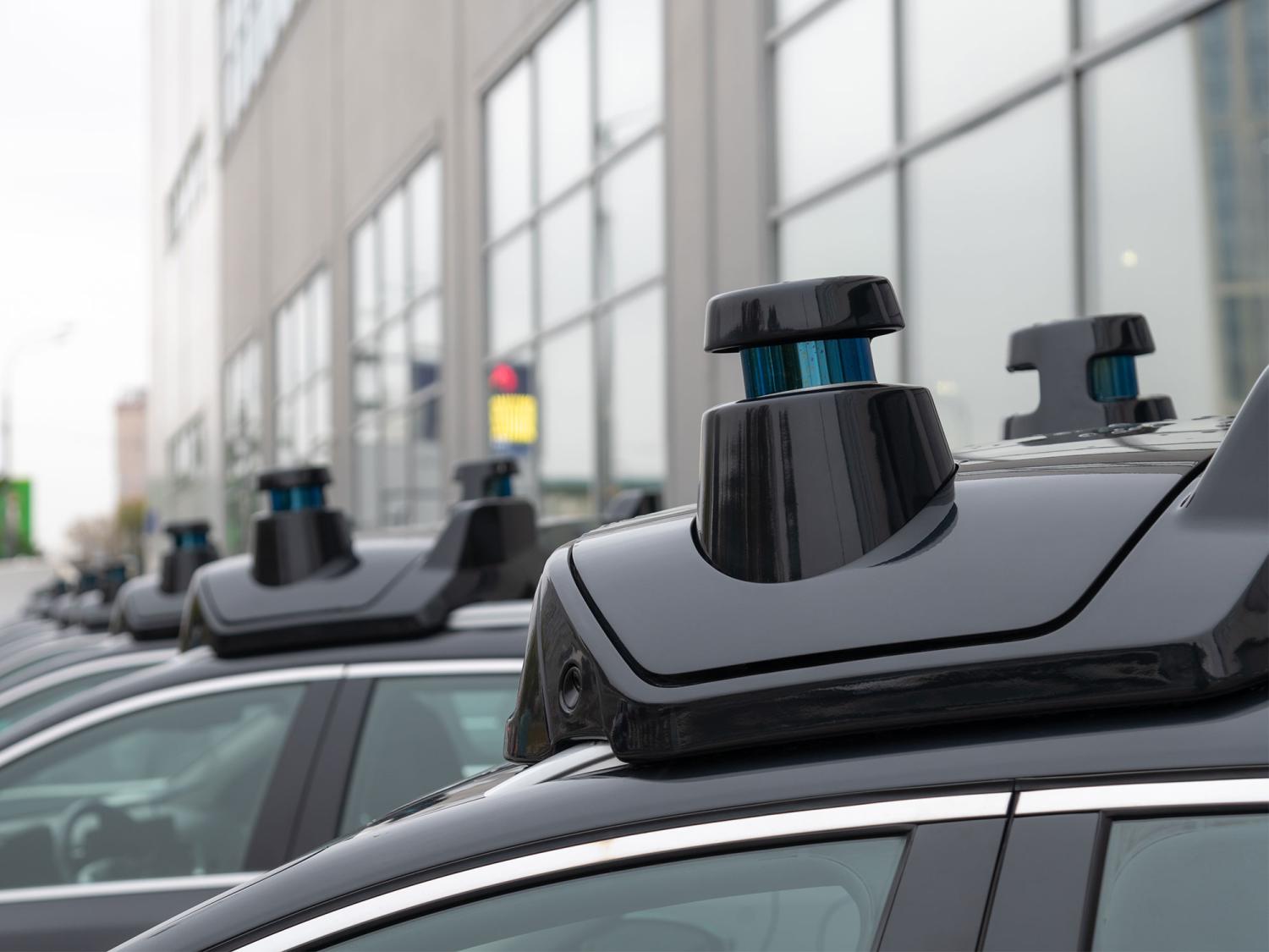 Close-up view of sensors and radar on roof of black autonomous driving vehicle (self-driving car or driverless car).