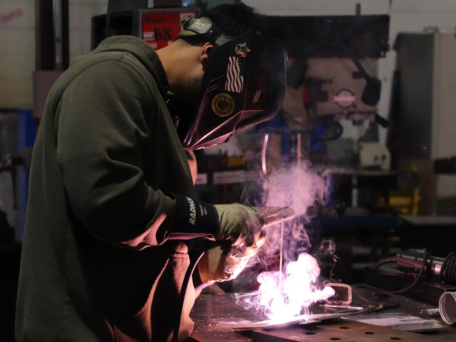 A welding student works on a project
