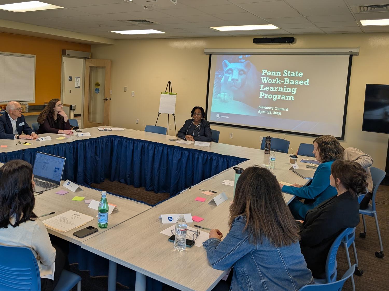 people sitting around a table looking at a presentation