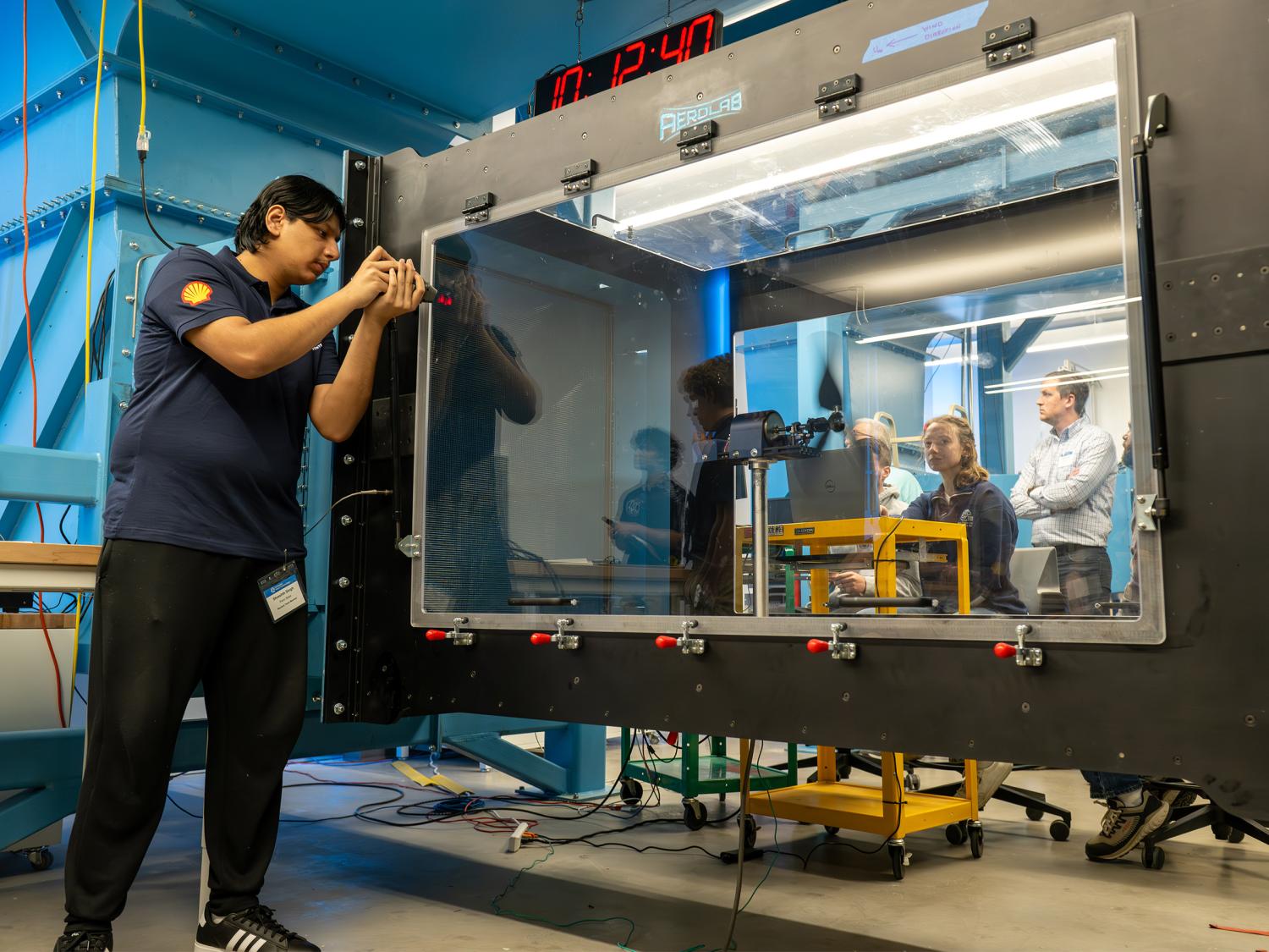 Students testing their prototype in a wind tunnel