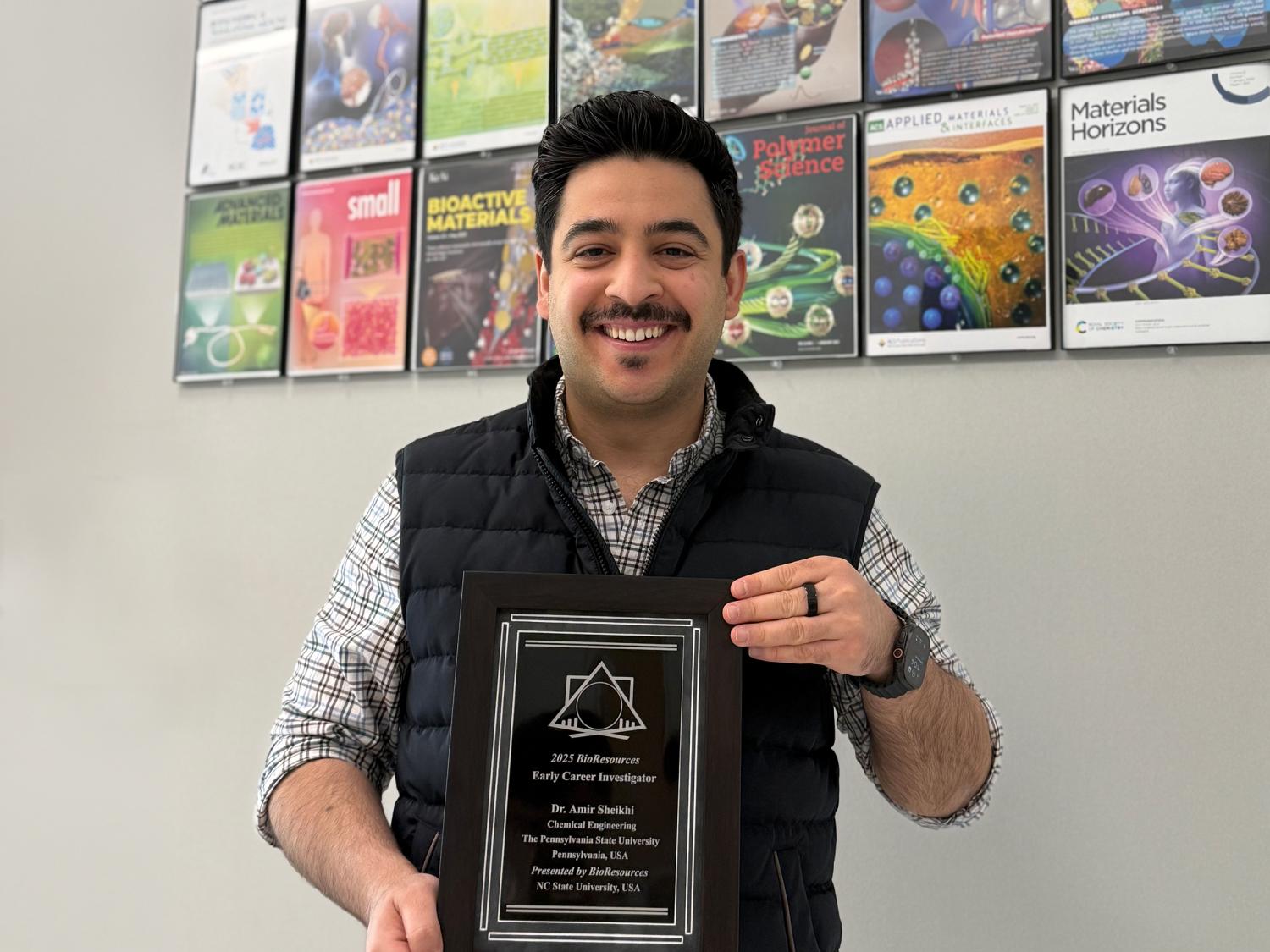 Amir Sheikhi holding an award plaque