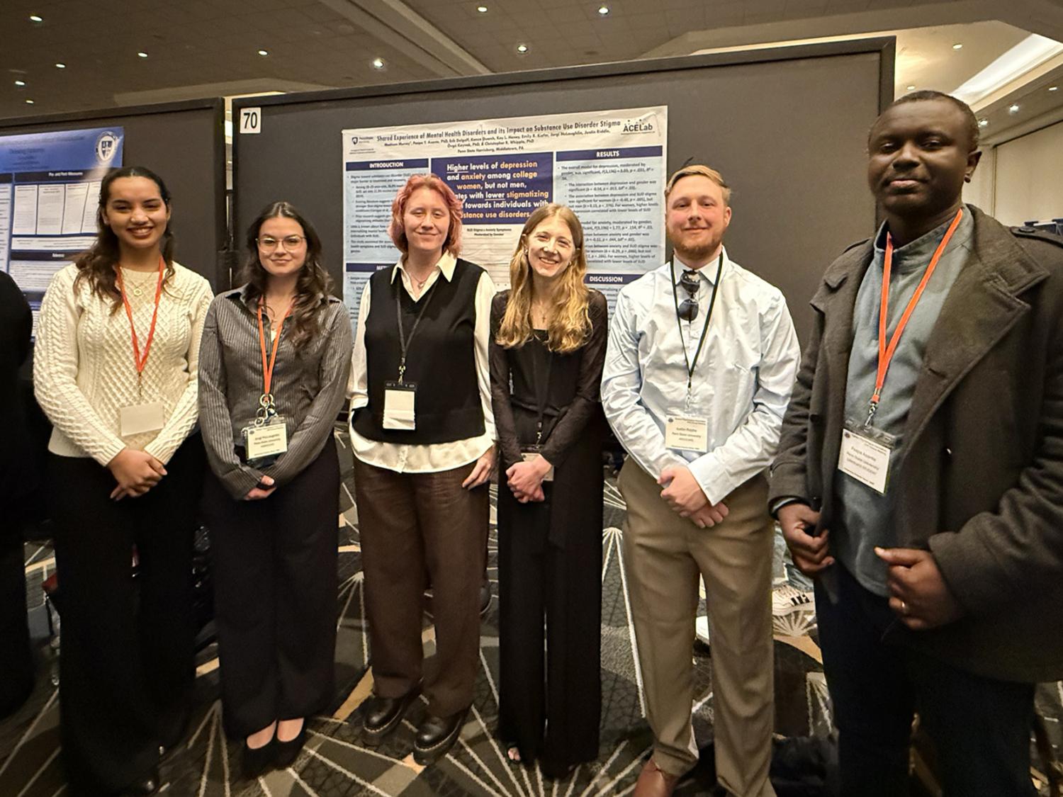a group of students pose with their research poster at a conference