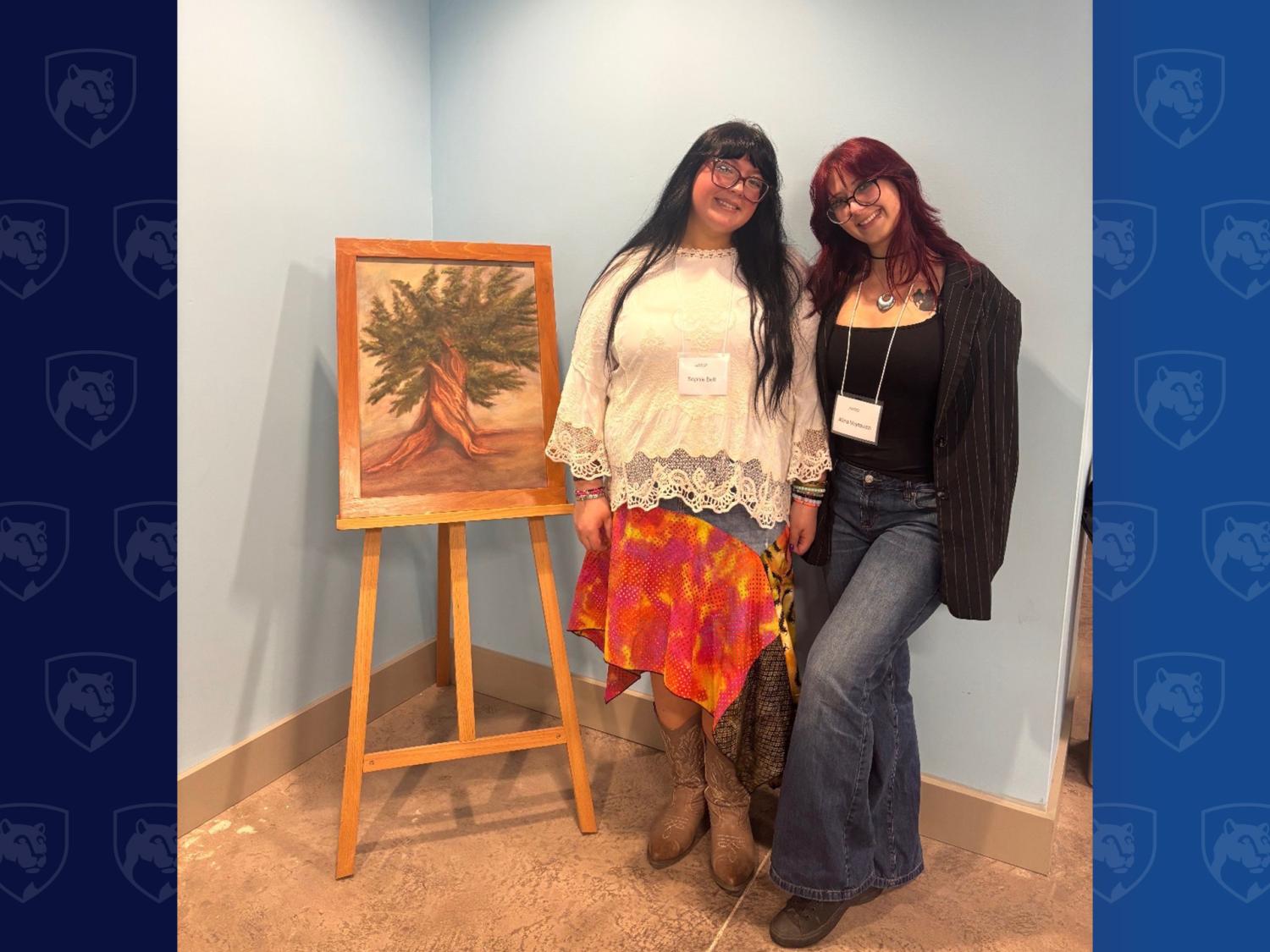Two people standing in front of a painting