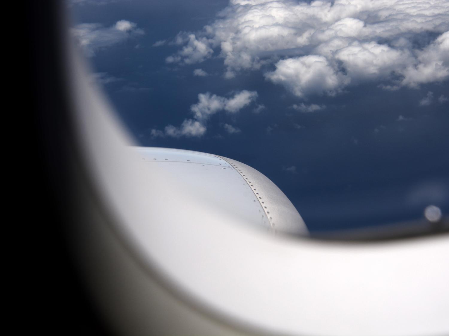 A photo looking outside an airplane in mid-flight, the wing partially in view