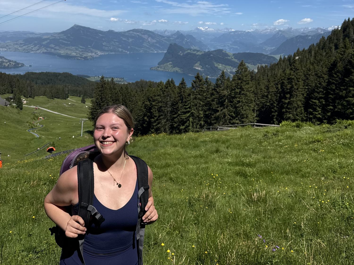 Person standing in a field with mountains visible in the background