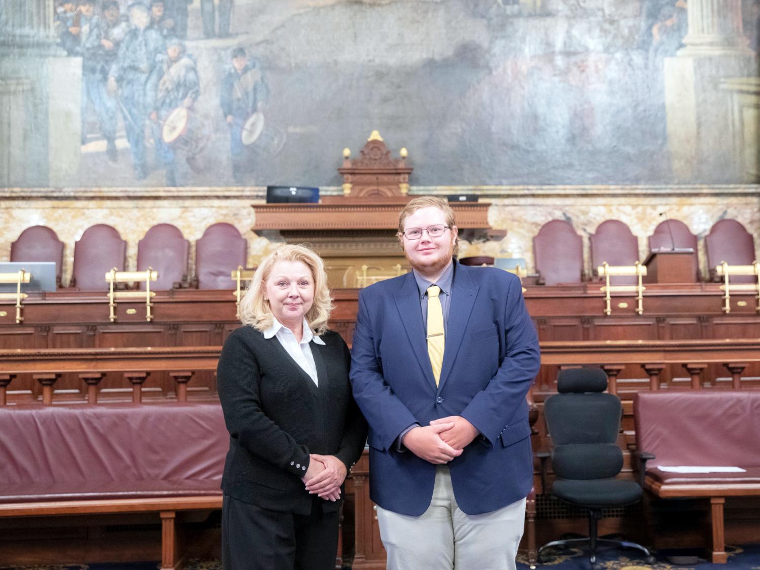 Woman and student stand next to each other in a room in the state capital