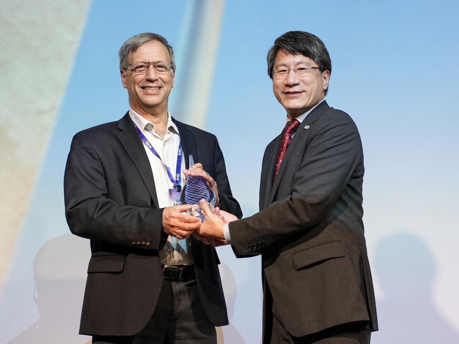 A professor of chemical engineering receives his award from the director of NIIMBL.