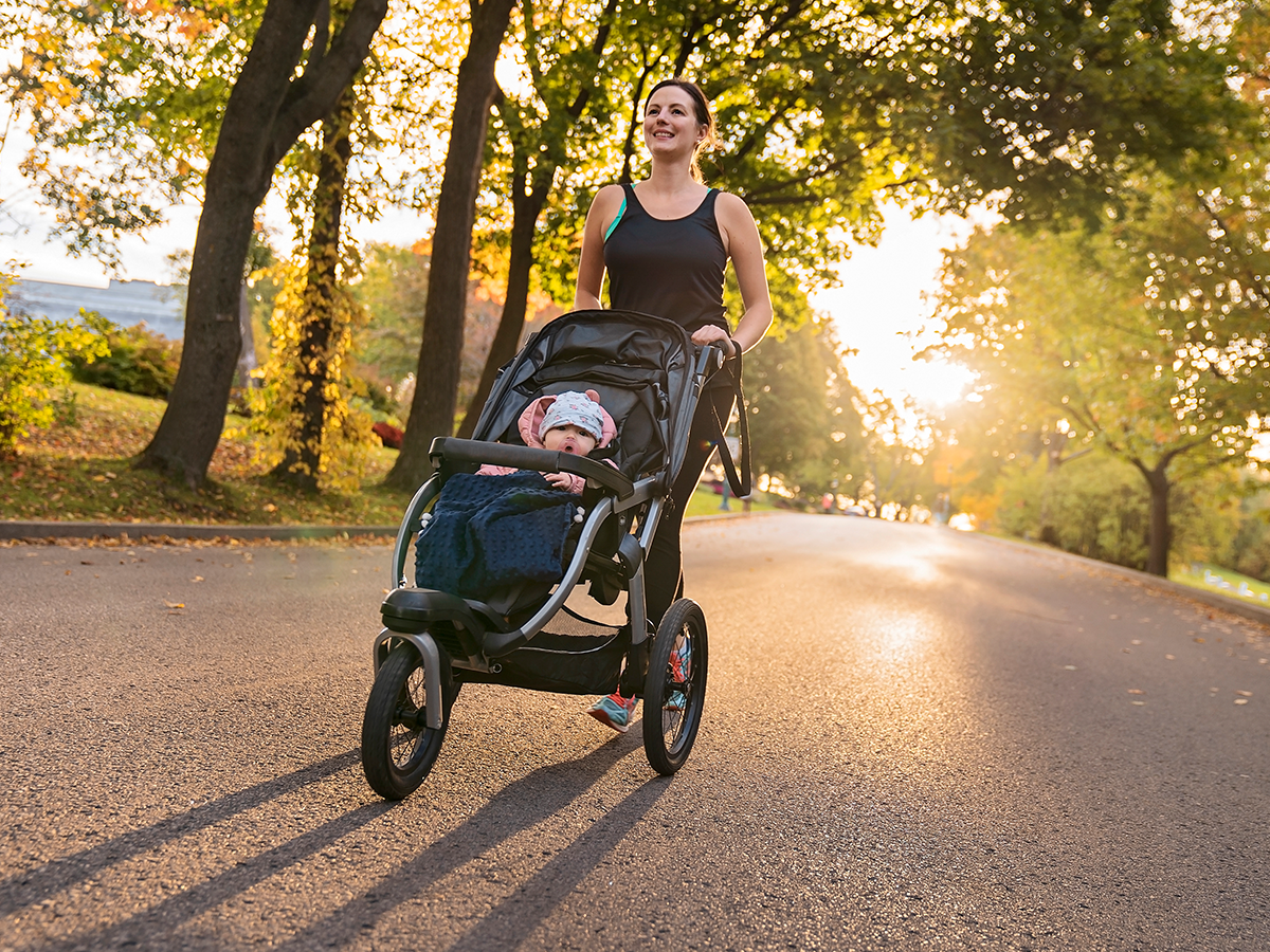 Woman running pushing child in jogging stroller