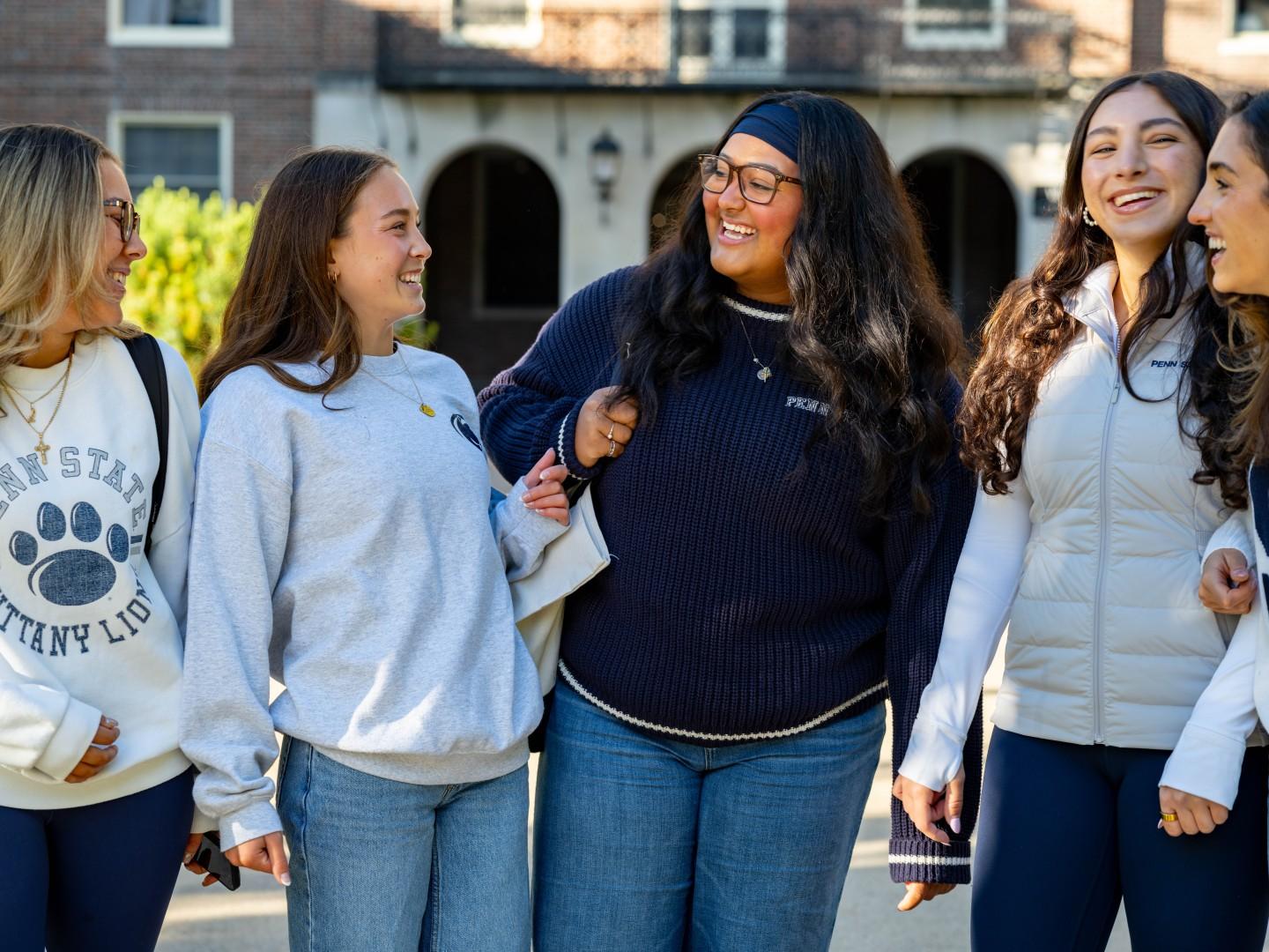 Five students wear blue and white Penn State gear