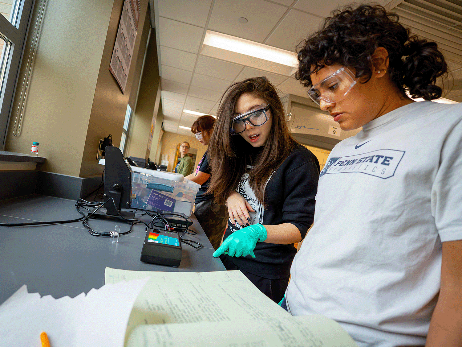 Two chemistry students work in a lab alongside each other
