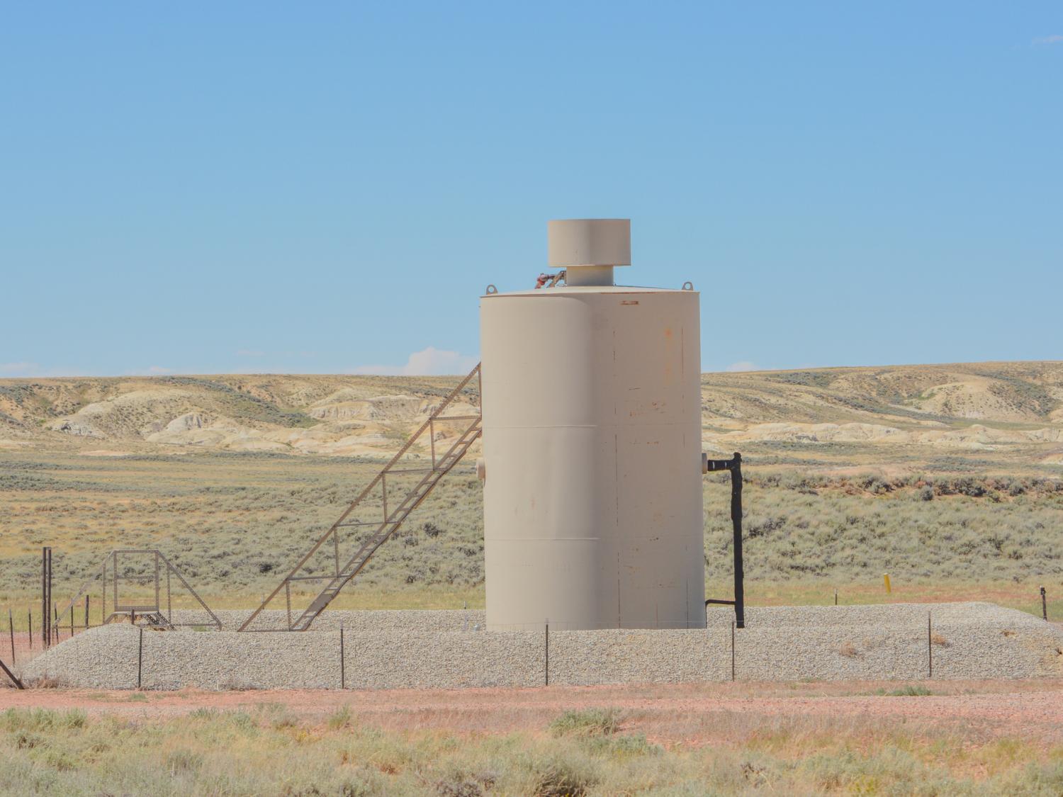 gas well equipment sits with a barren landscape from the American West in the background