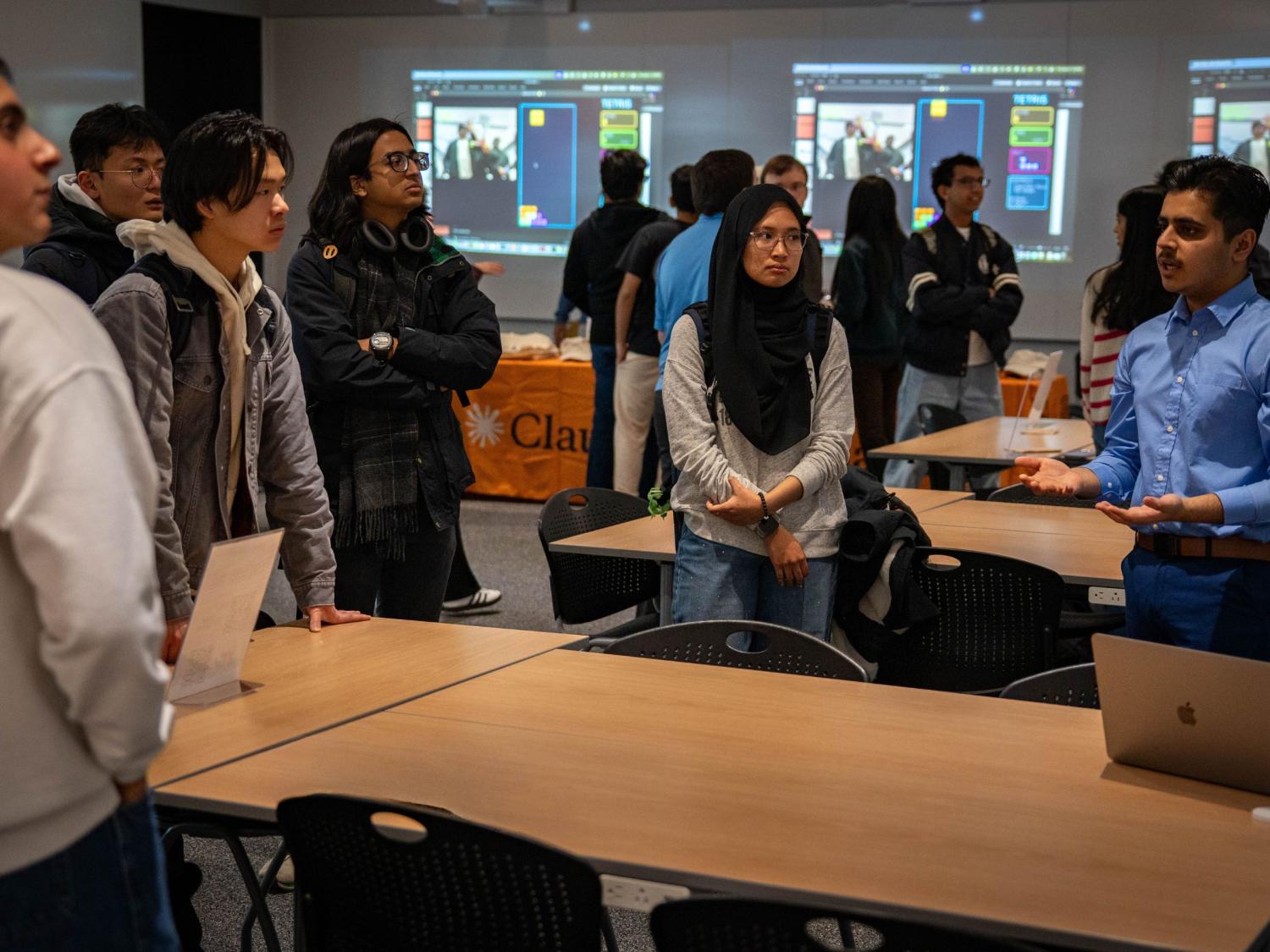 group of college students gather around large conference room to chat