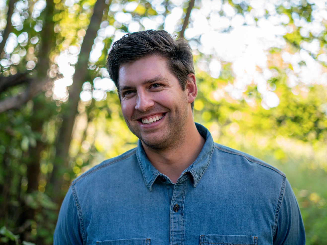 Noah Davis wears a blue shirt while standing outdoors
