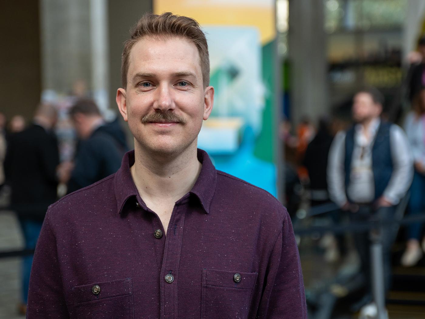 Smiling man with short brown hair and a mustache