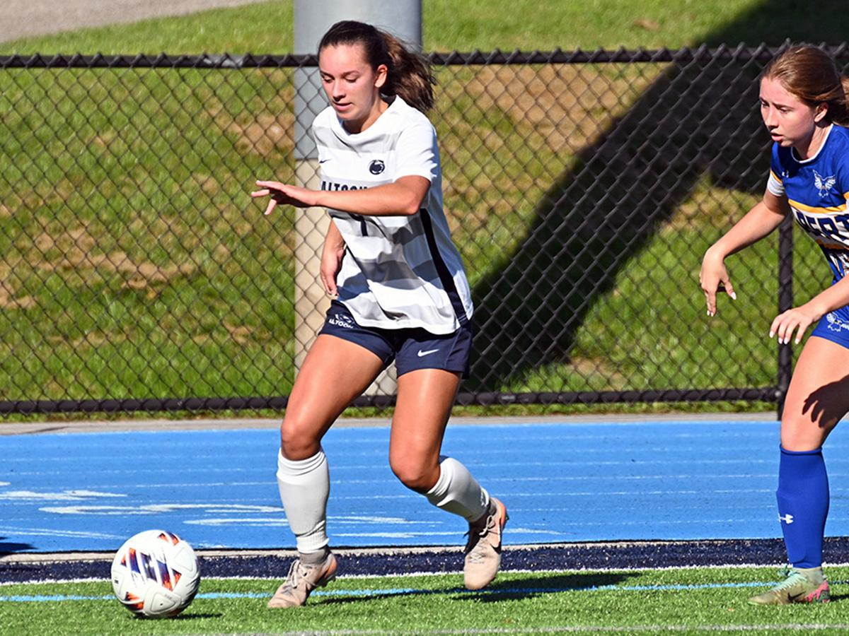 Penn State Altoona soccer player Kira Trexler controls the ball during a game as an opposing player defends.