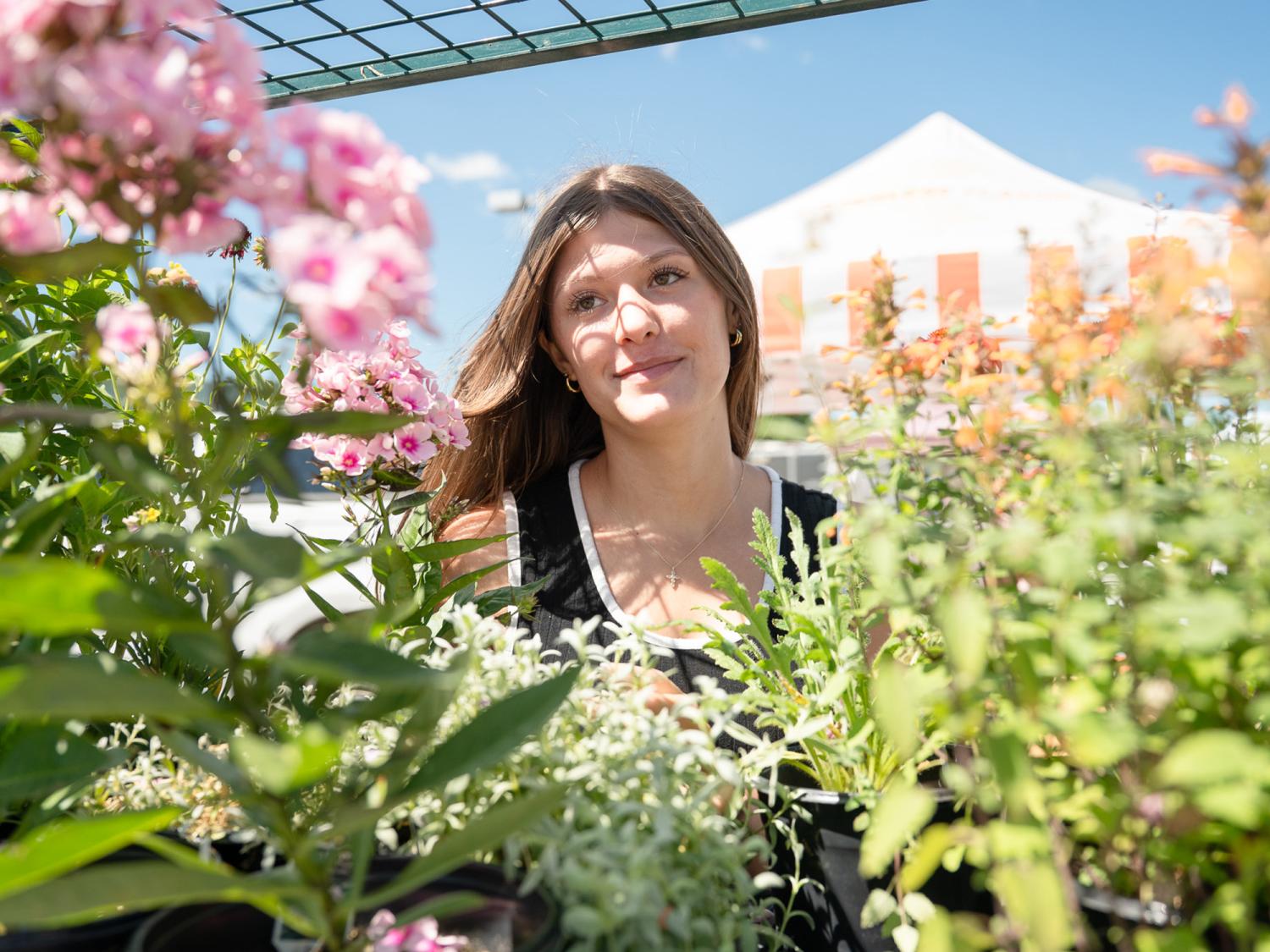 Penn College student Karleigh Hunter stands among flowers.