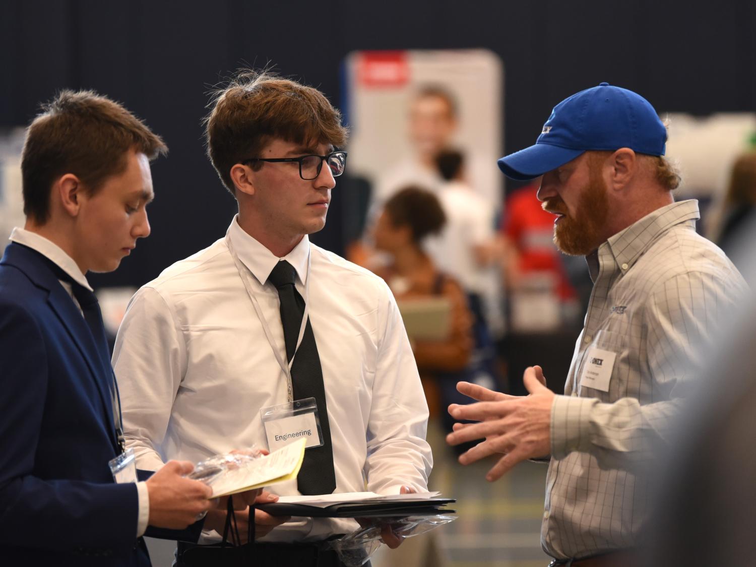 Two students talk with a recruiter at Penn State Behrend's fall Career and Internship Fair.