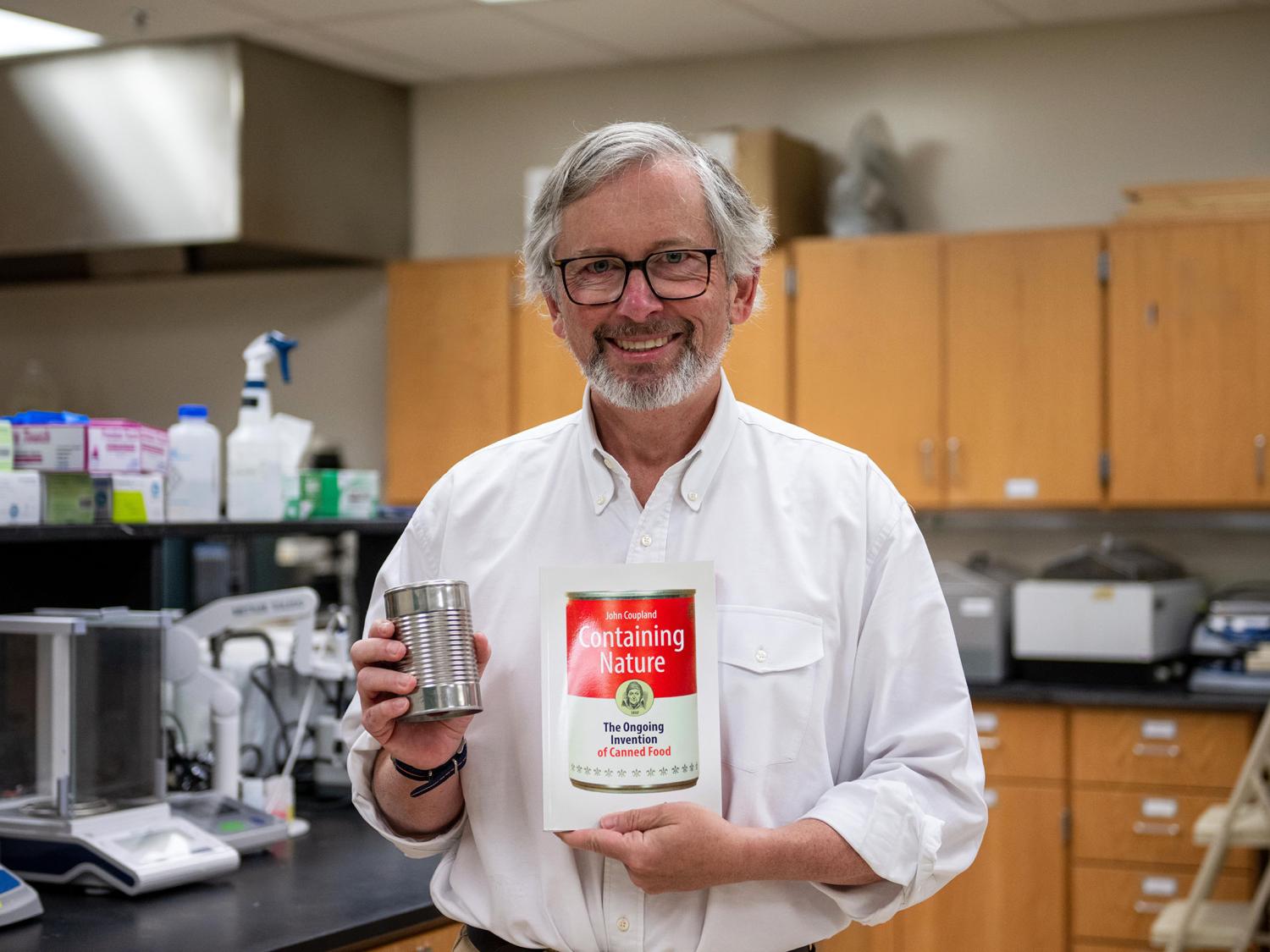 a researcher holds a book and a can