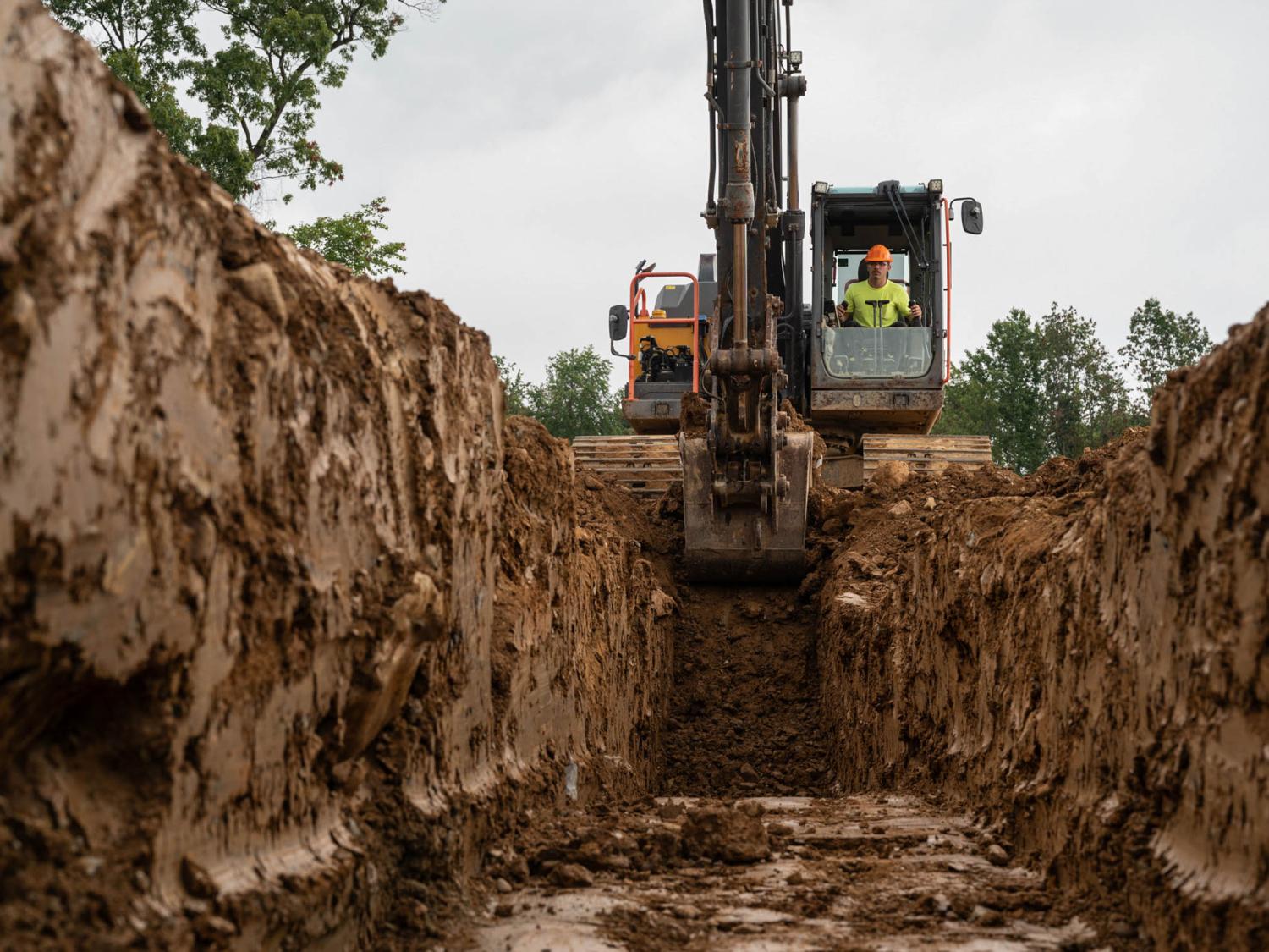 A large piece of machinery equipment digging a trench