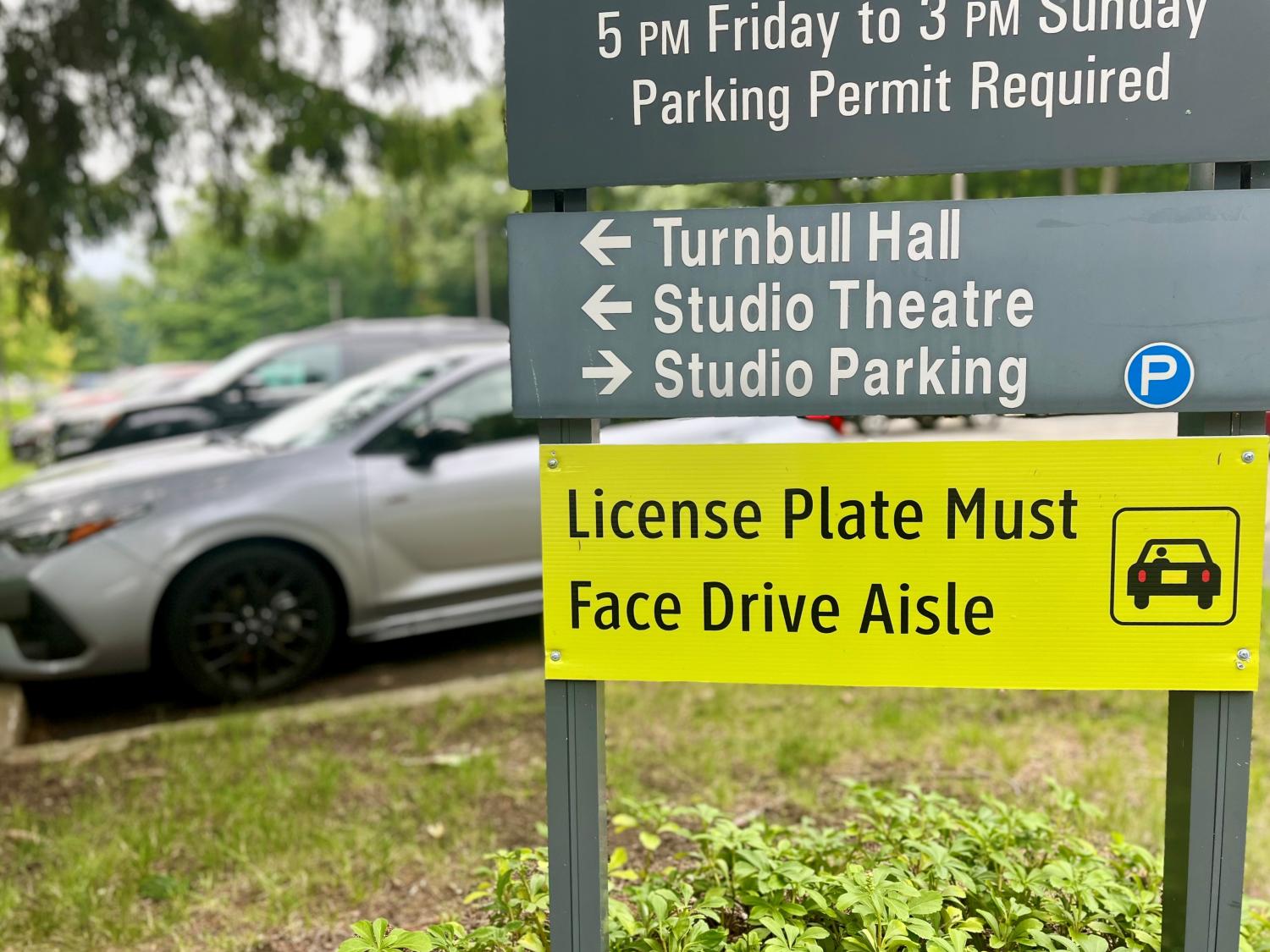 Signage in a parking lot at Penn State Behrend reads "License Plate Must Face Drive Aisle."