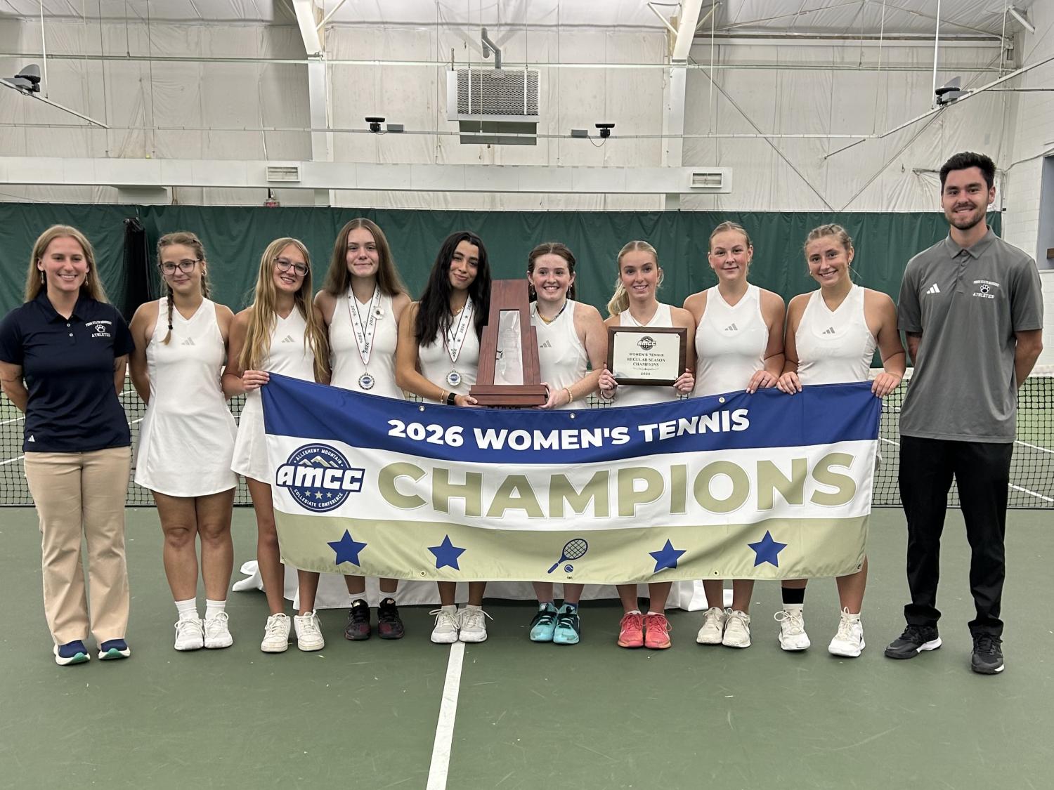 The Penn State Behrend women's tennis team poses with the AMCC championship banner.