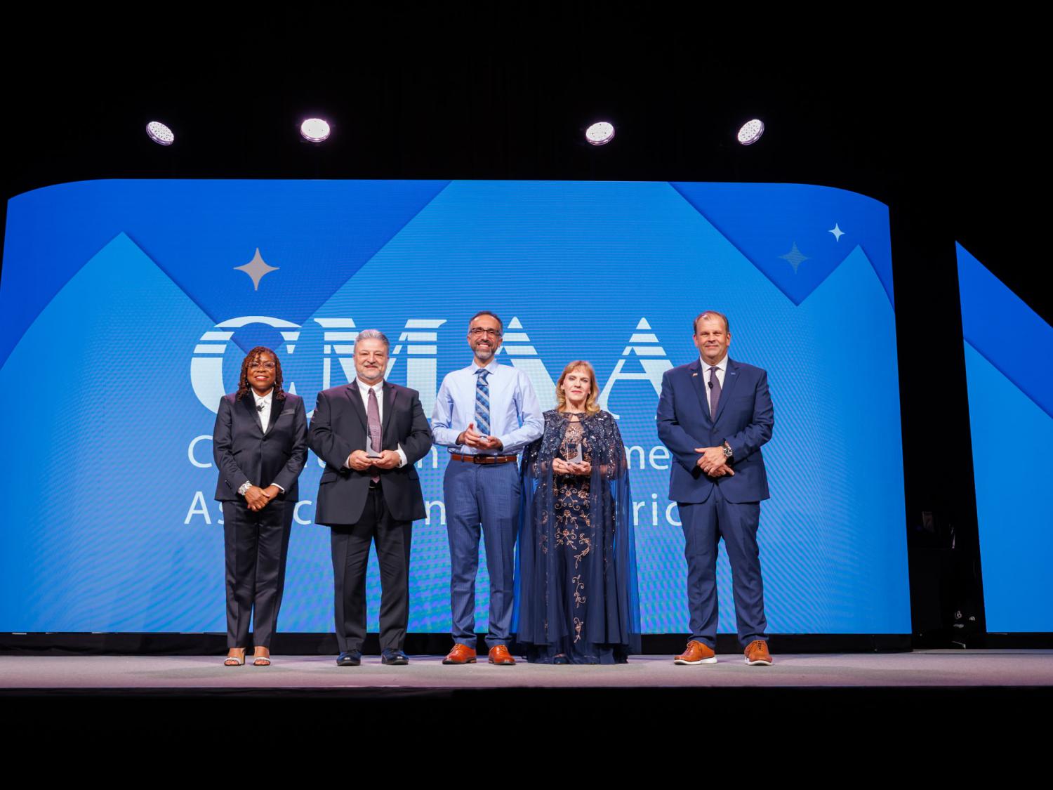 A group of people stand on a stage for an awards ceremony