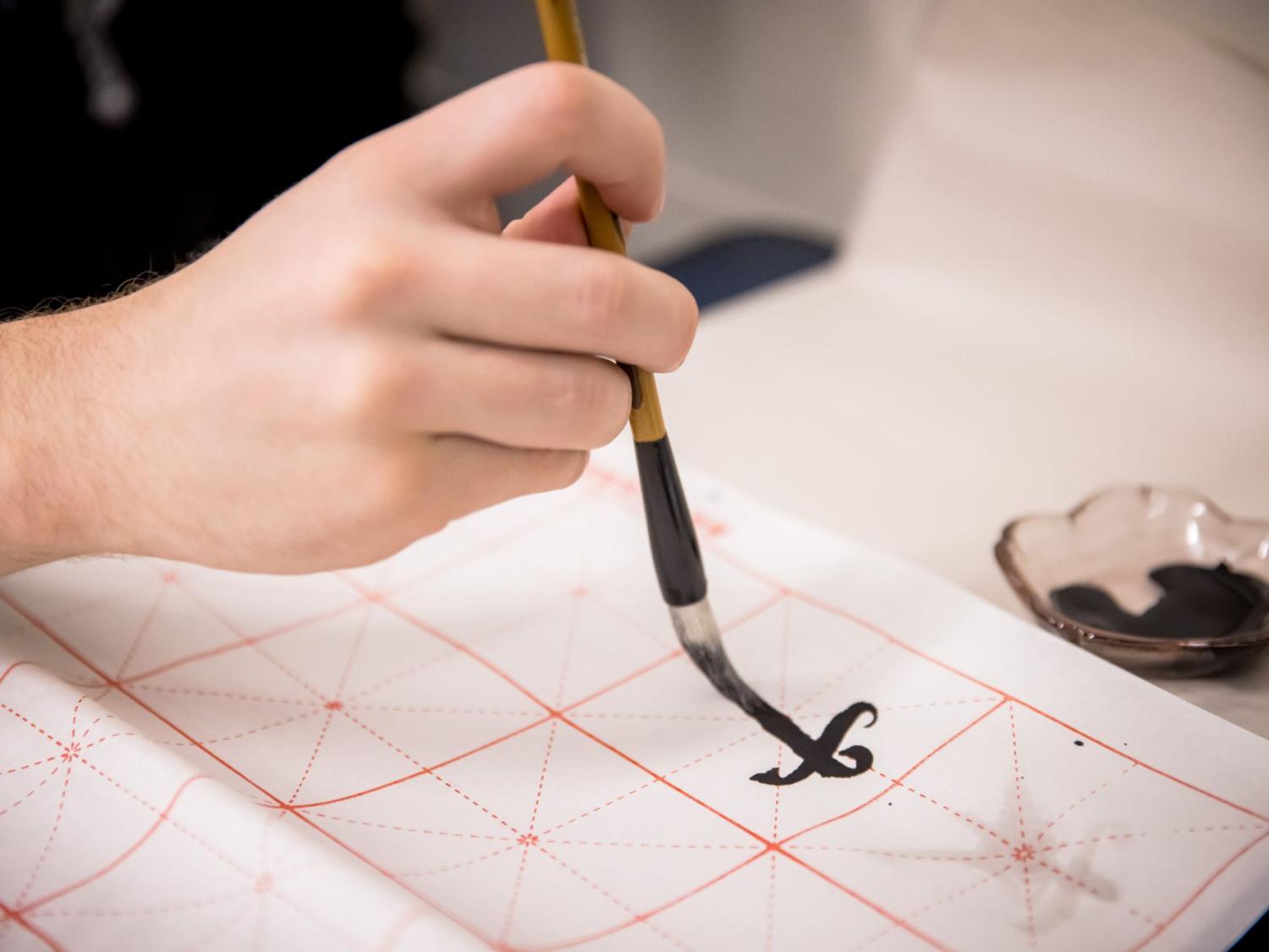 A student practices Chinese script in a writing course at Penn State Behrend.
