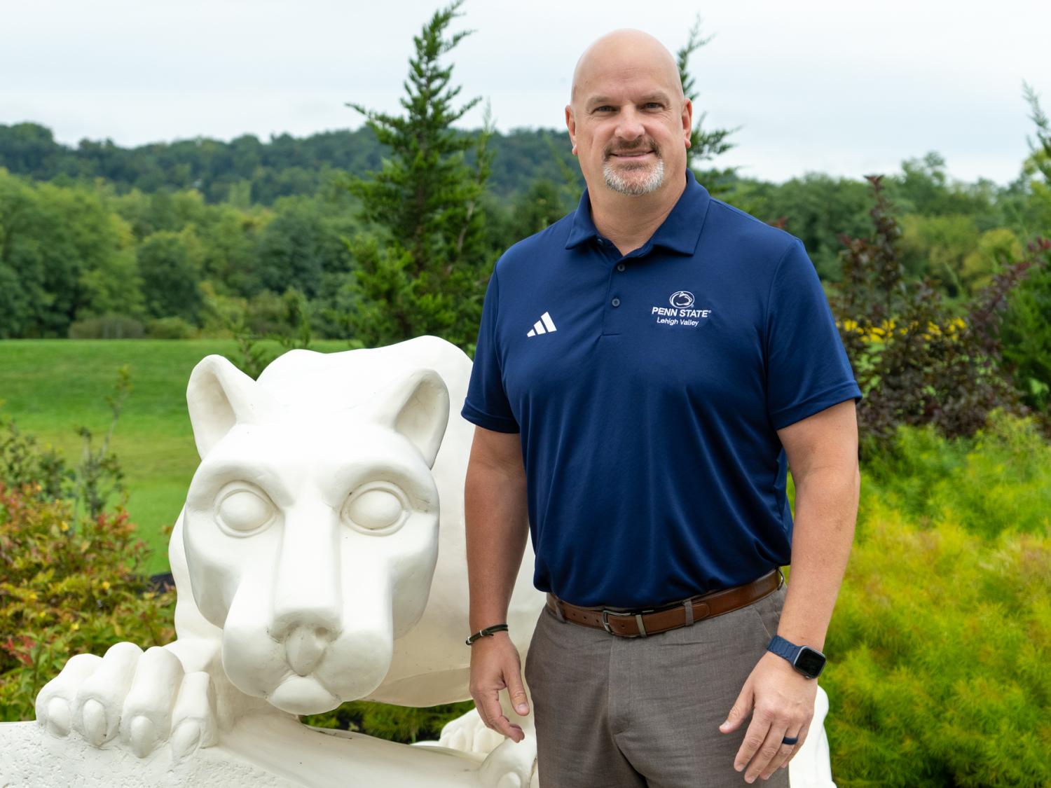 John Vandevere stands next to Nittany Lion Shrine