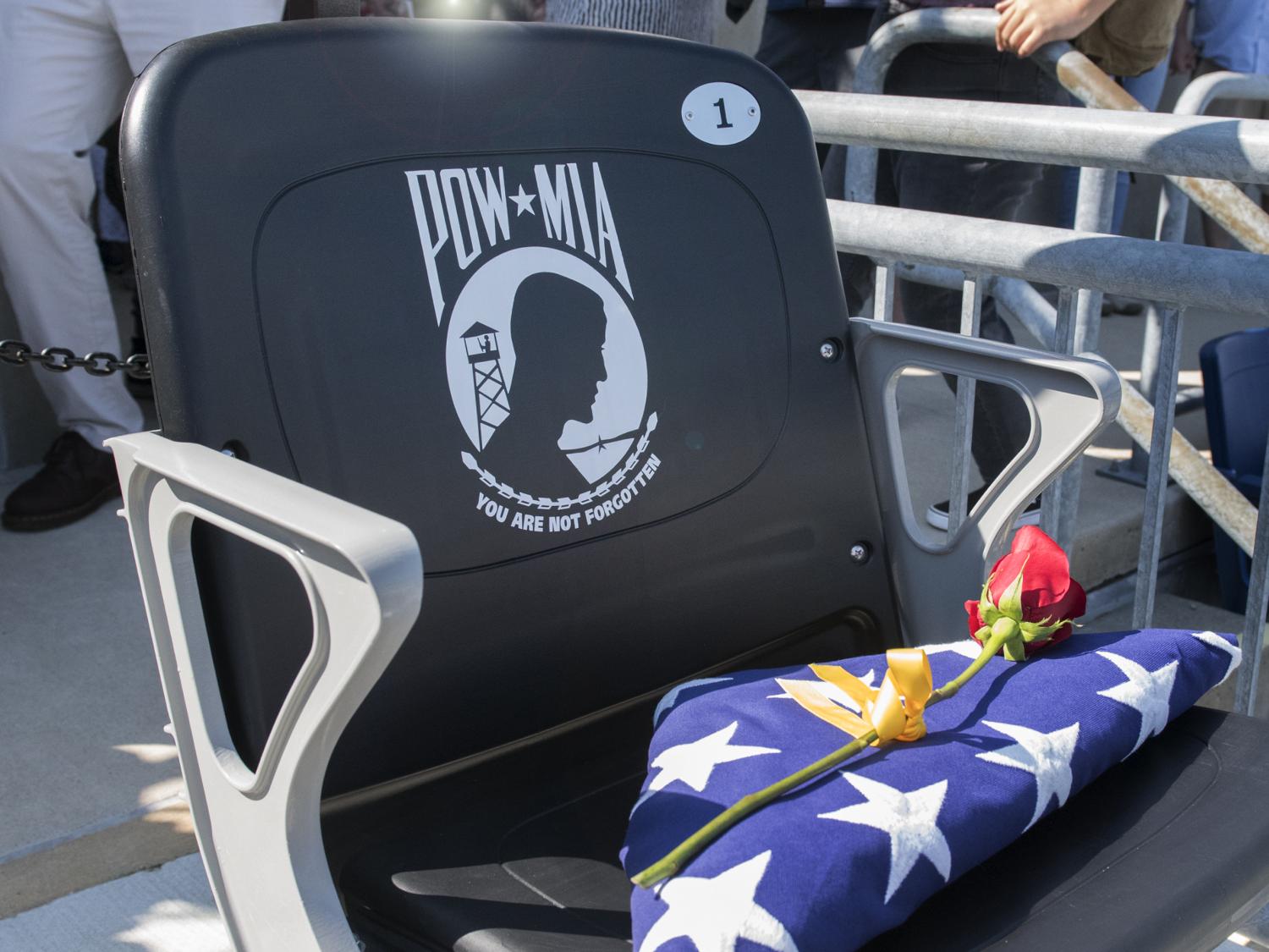 The POW/MIA Chair of Honor is shown with a folded American flag and red rose in the Beaver Stadium.