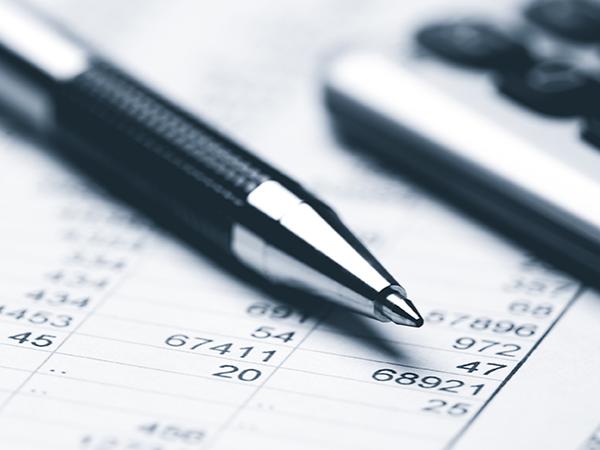 A pen and a calculator on top of tax documents