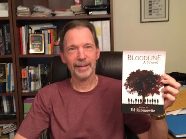 Ed Rabinowitz holds up a copy of his book, "Bloodline"