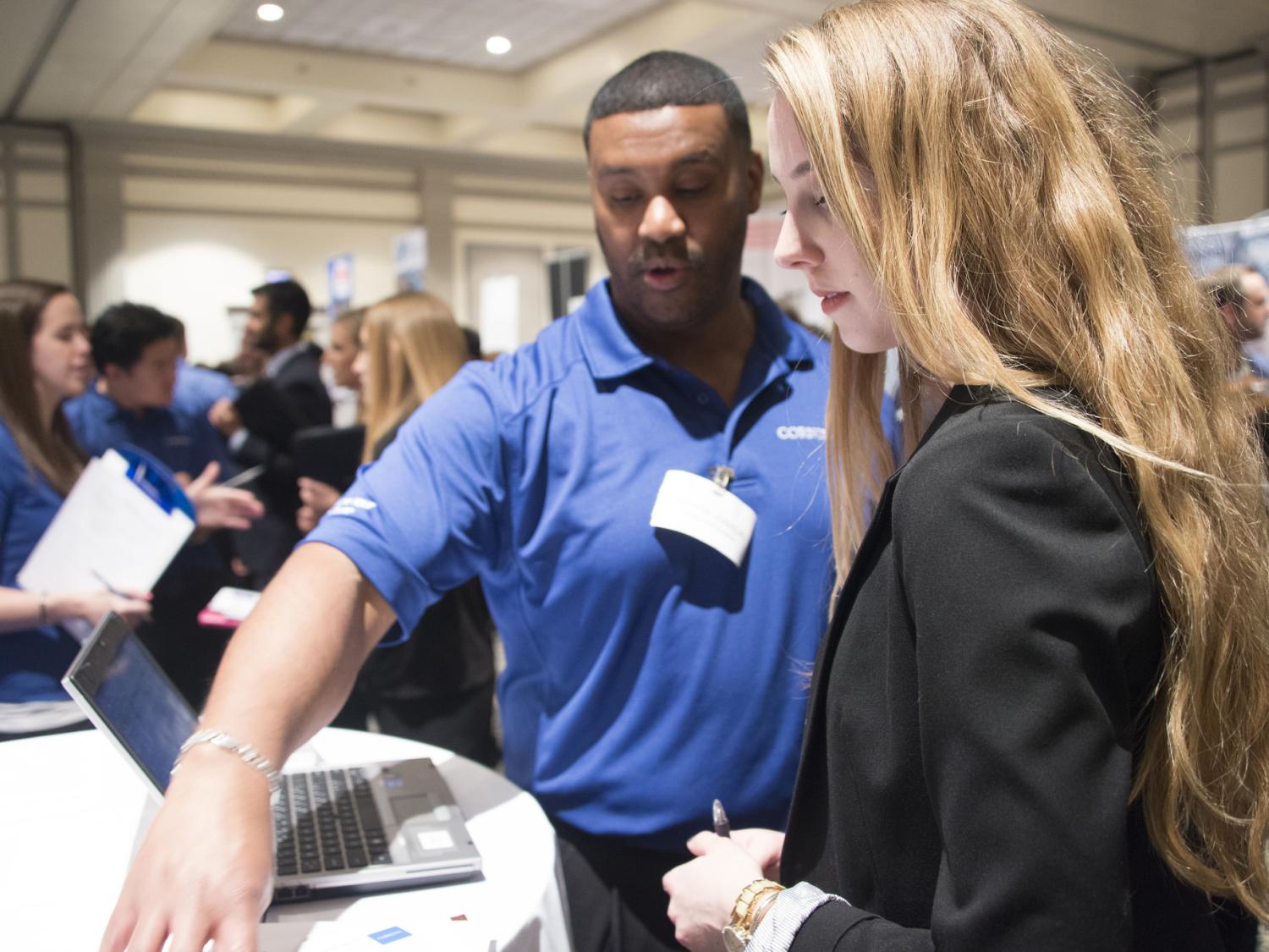 A student attends a career fair and meets with a corporate recruiter.