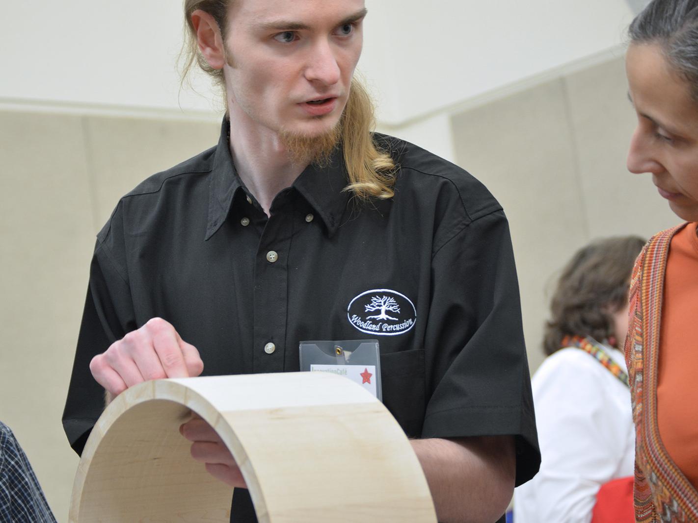 A man shows the construction elements of his drums.