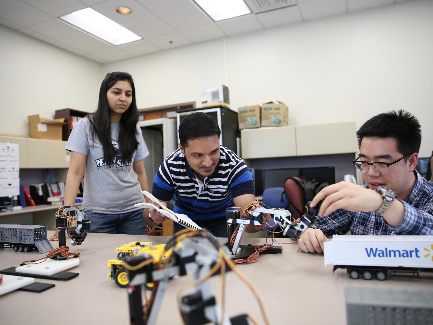 Industrial engineering graduate students work on a fleet operations model in an engineering lab