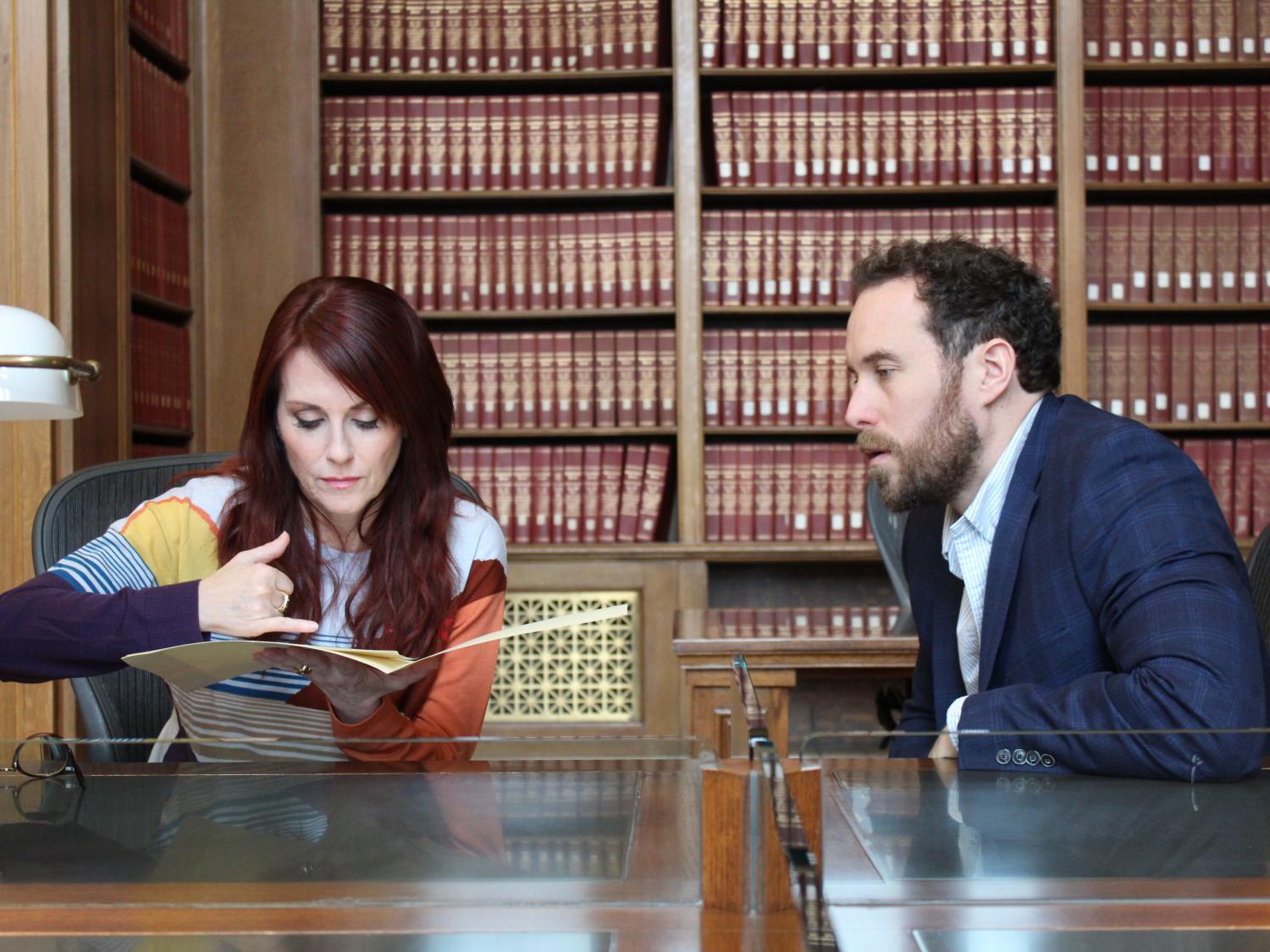 Two people work at a researcher's table at the National Archives in Washington, D.C.
