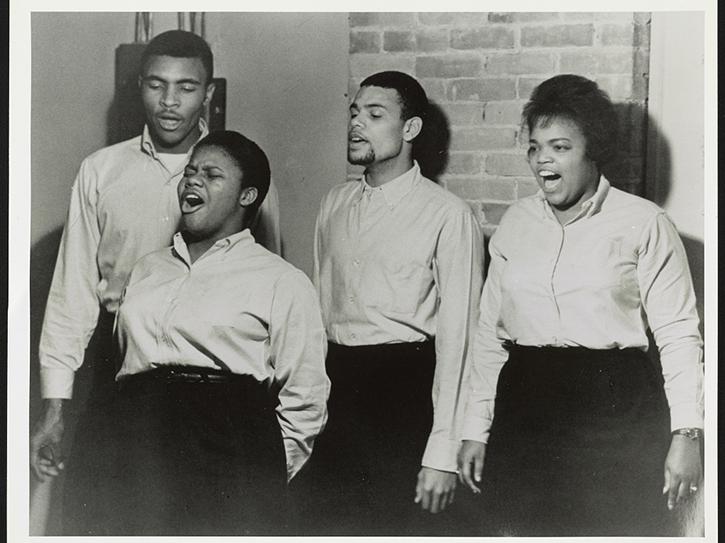 Black-and-white photo of four people singing freedom songs in 1963