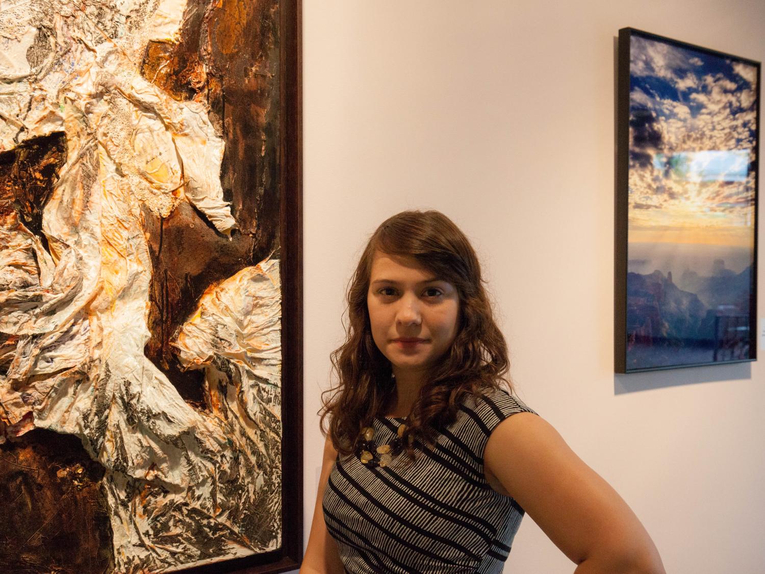 Haley Finnegan stands beside a work of art in the Woskob Family Gallery. 