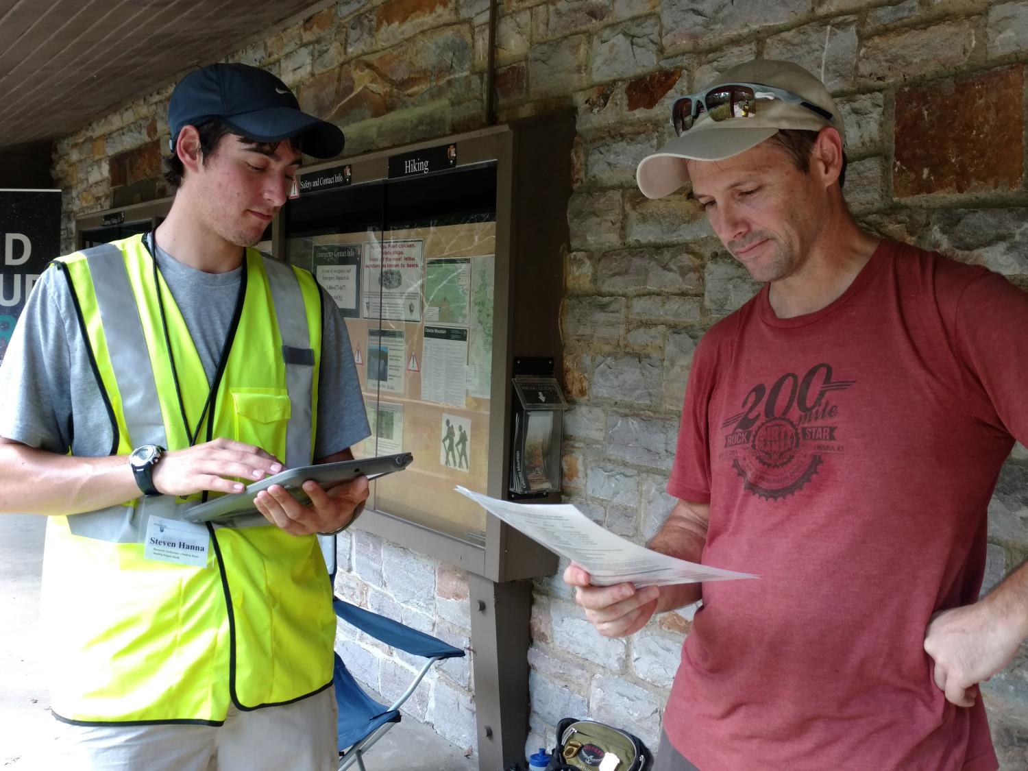 A research team member surveys a park visitor