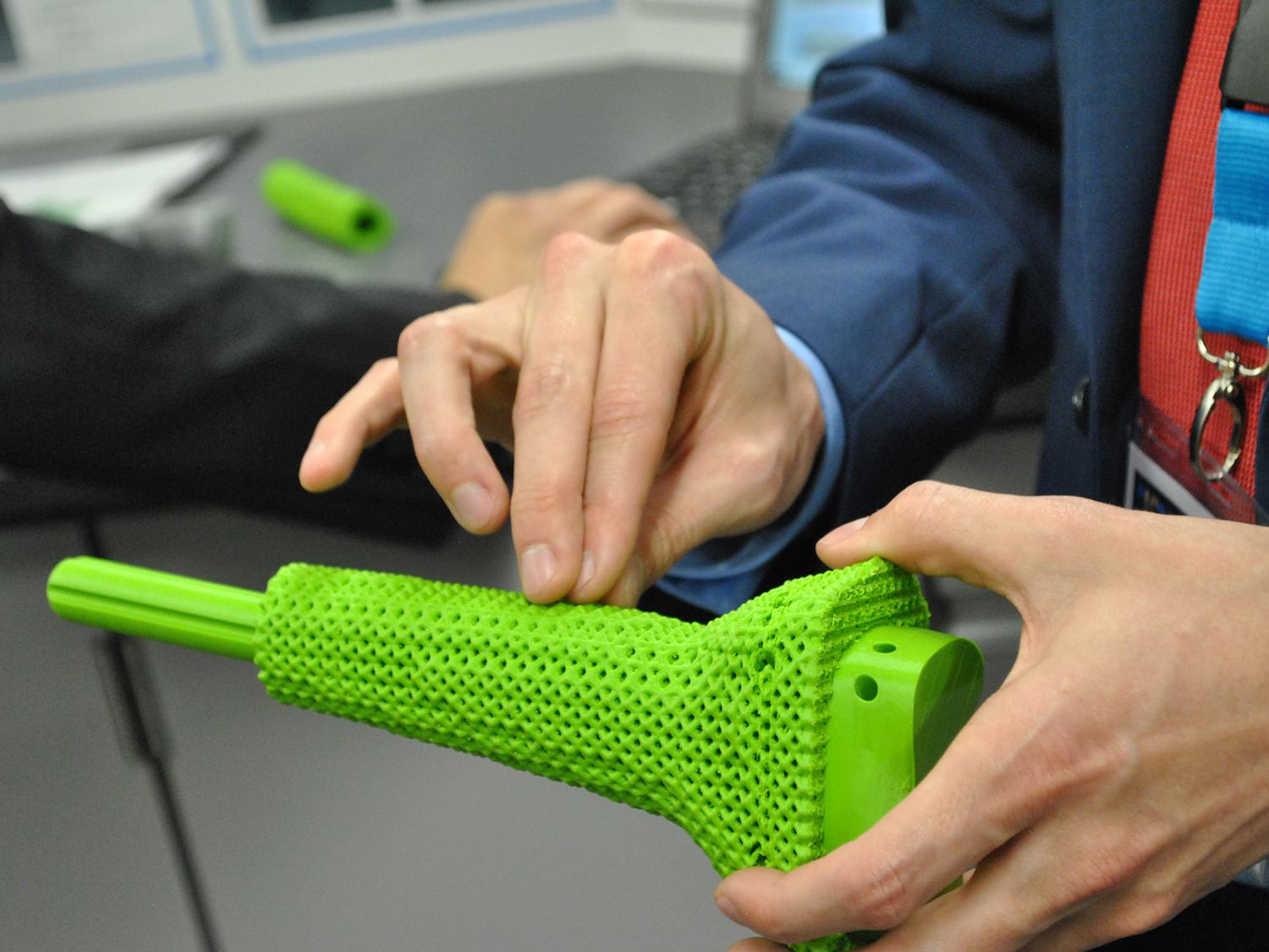 student holding 3D printed prosthetic 