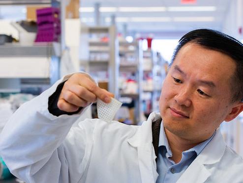 Man in white lab coat reviews material.