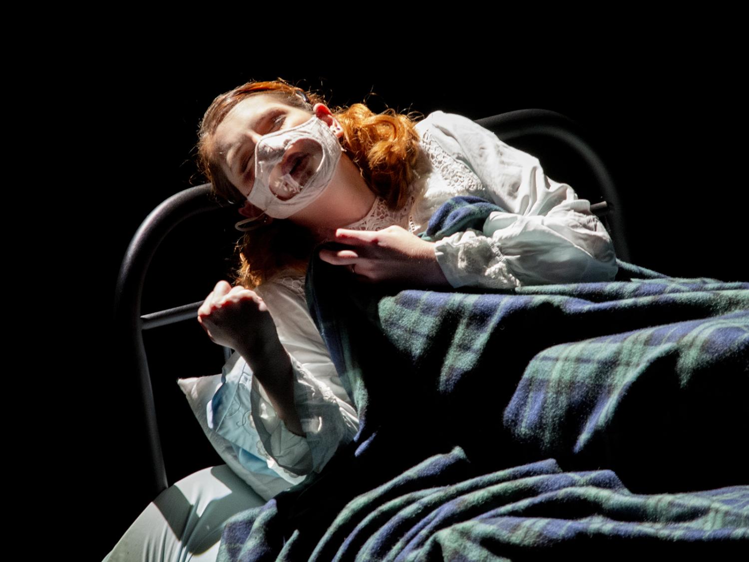 actress performing in bed on stage